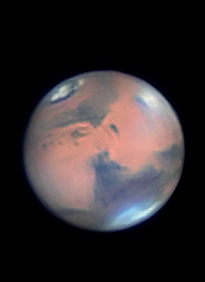 Marte, che mostra chiaramente le nuvole nella zona del grande vulcano a scudo Elysium Mons. Si nota bene anche la calotta polare settentrionale, molto ridotta. Mario Weigand