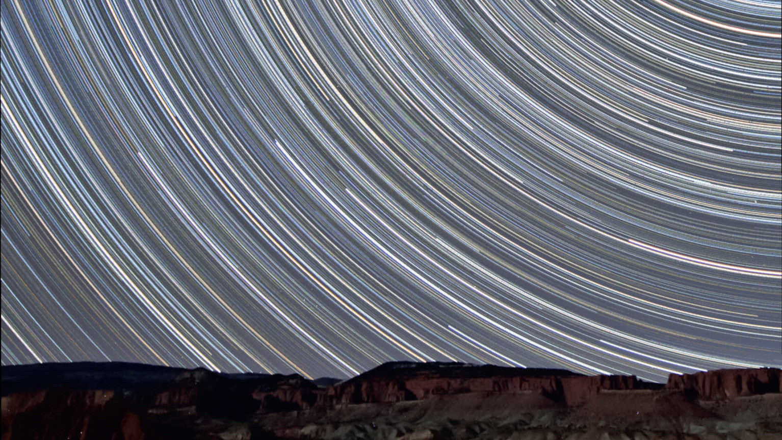 Questa immagine è stata scattata a pochi chilometri dal parco nazionale di Capitol Reef, nello Utah (USA), guardando verso nord, e mostra il percorso delle stelle sopra le rocce di arenaria rossa illuminate dalla Luna crescente. Per ottenerla sono stati combinati 350 scatti con un tempo di esposizione di 90 secondi ciascuno (tempo di esposizione totale: 525 minuti = 8,75 ore). L'immagine è stata scattata con un obiettivo 10-20 mm (a 10 mm e f/4) su una reflex digitale Canon 450D. U. Dittler
